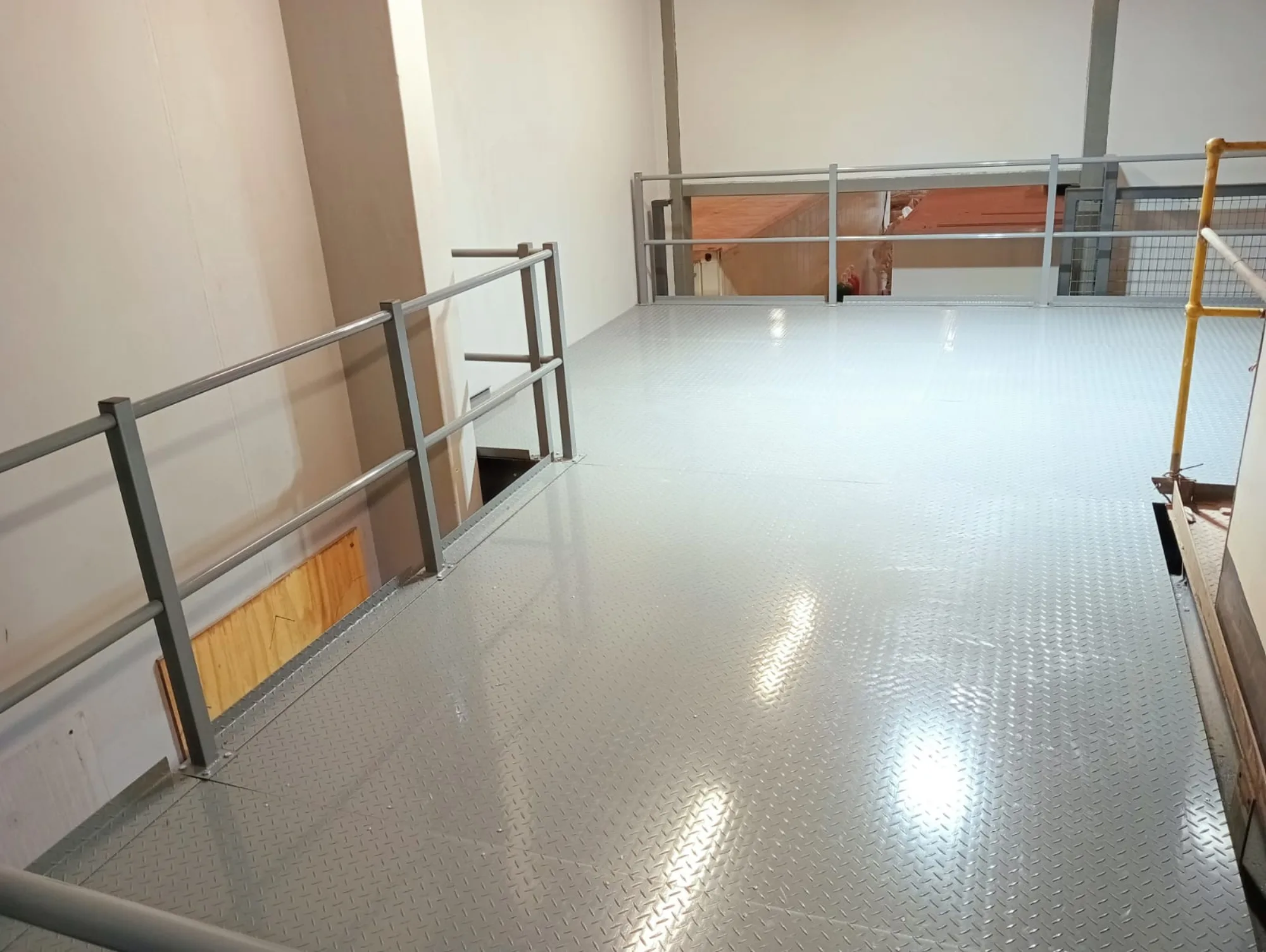 Steel chequer plate mezzanine deck with tubular handrail