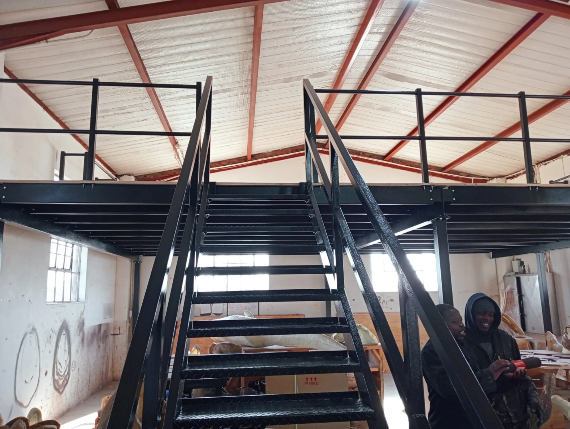 Steel stair rising to the new mezzanine deck inside the studio
